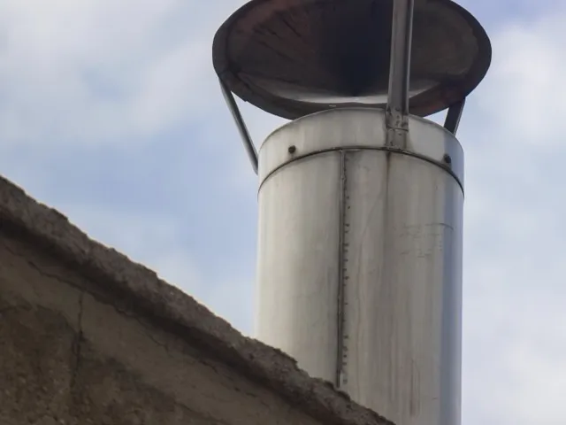 Korszerű fém béléscső a tetőn, kéményseprő sapkával